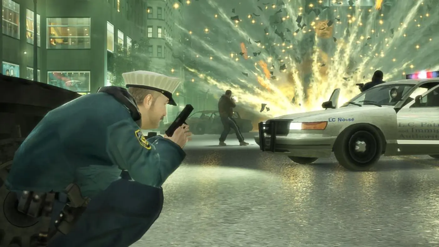 Fusillade nocturne dans GTA IV : un policier de Liberty City à couvert, une explosion et une voiture de police devant des immeubles éclairés