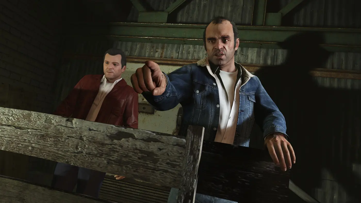 Trevor pointant du doigt, Michael derrière lui dans un hangar, dans GTA 5