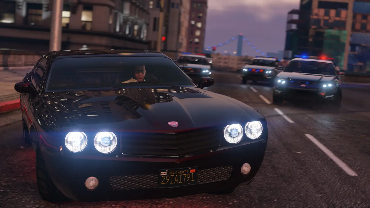 Un personnage de GTA 5 au volant d'une muscle car noire poursuivi par plusieurs voitures de police dans les rues de Los Santos au crépuscule