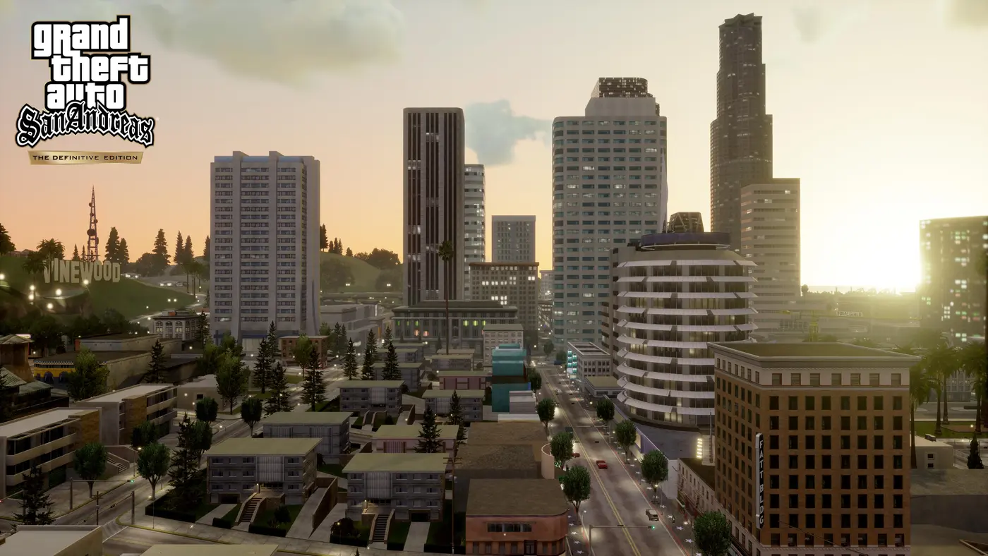Capture officielle de GTA San Andreas The Definitive Edition : le centre-ville de Los Santos au coucher du soleil, gratte-ciel, quartiers résidentiels au premier plan et panneau Vinewood sur la colline