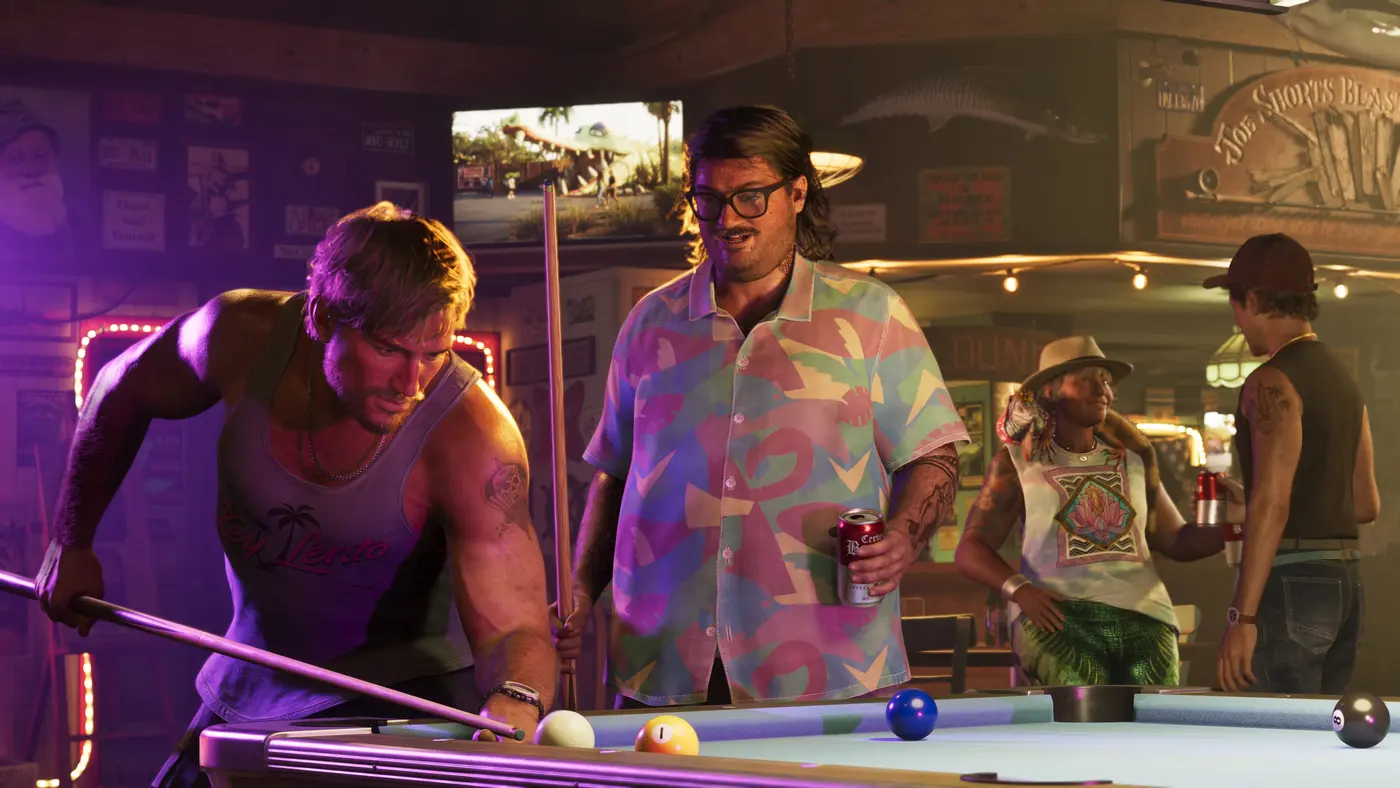 Intérieur d'un bar de quartier dans GTA VI : deux hommes autour d'une table de billard sous des néons violets, l'un se penche pour jouer son coup, l'autre tient une canette de bière, décor de murs couverts d'affiches et d'un poisson empaillé