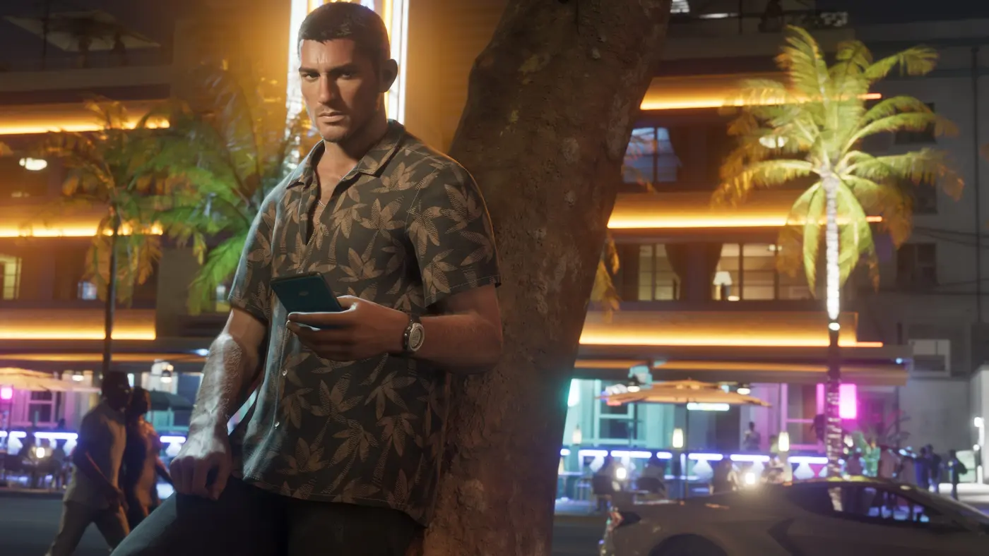 Jason Duval seul, adossé à un arbre dans une rue de Vice City la nuit, smartphone en main, façades éclairées de néons chauds et passants en arrière-plan