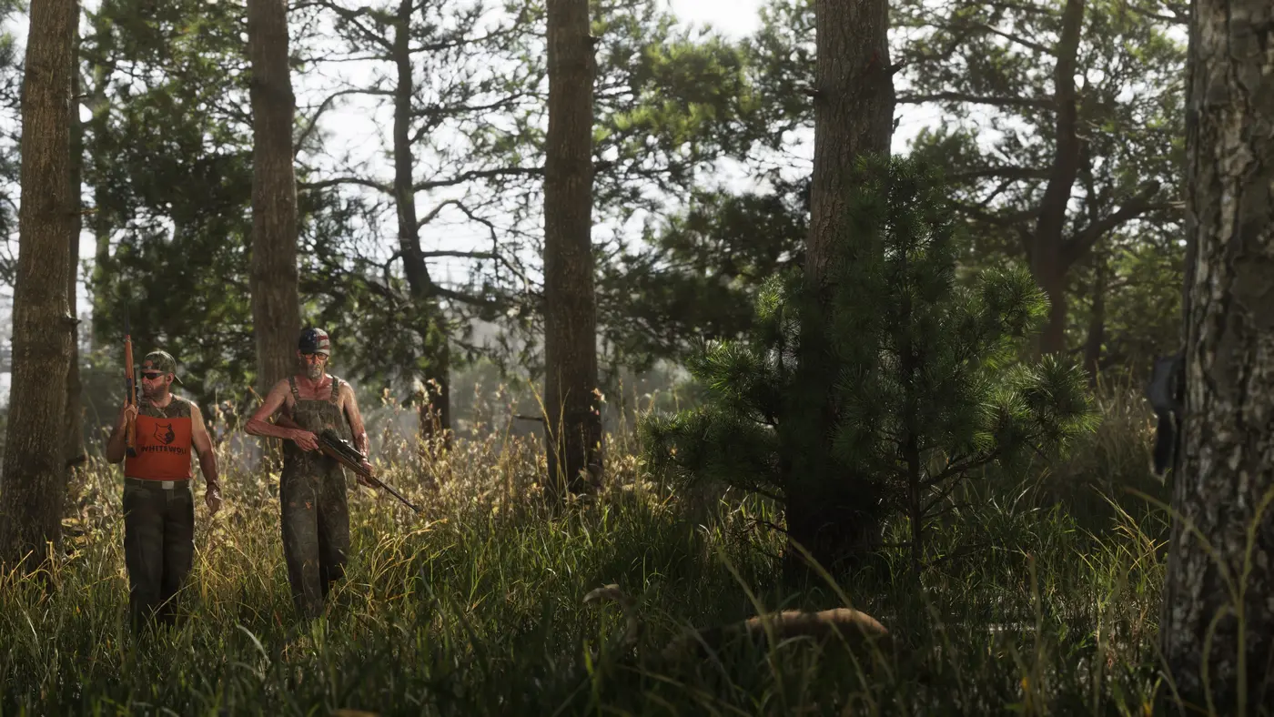 Deux chasseurs marchant fusil à la main dans une forêt de pins ensoleillée de Mount Kalaga dans GTA VI, l'un en débardeur orange, l'autre en salopette de camouflage, hautes herbes et lumière filtrant à travers les arbres