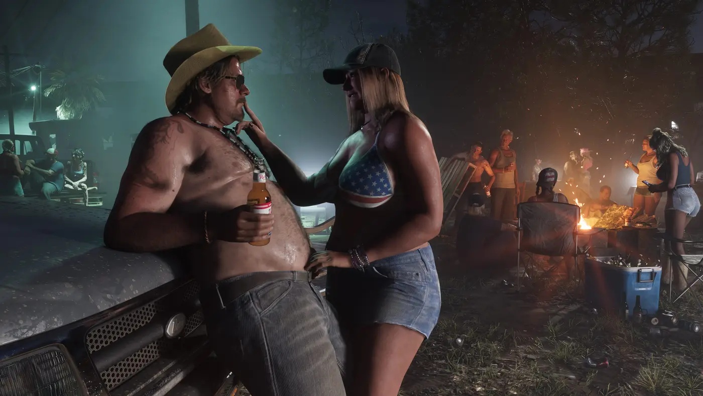 Fête nocturne autour d'un feu dans GTA VI : un homme torse nu en chapeau de cowboy tient une bière à l'étiquette rouge et blanche, face à une femme en haut aux couleurs du drapeau américain