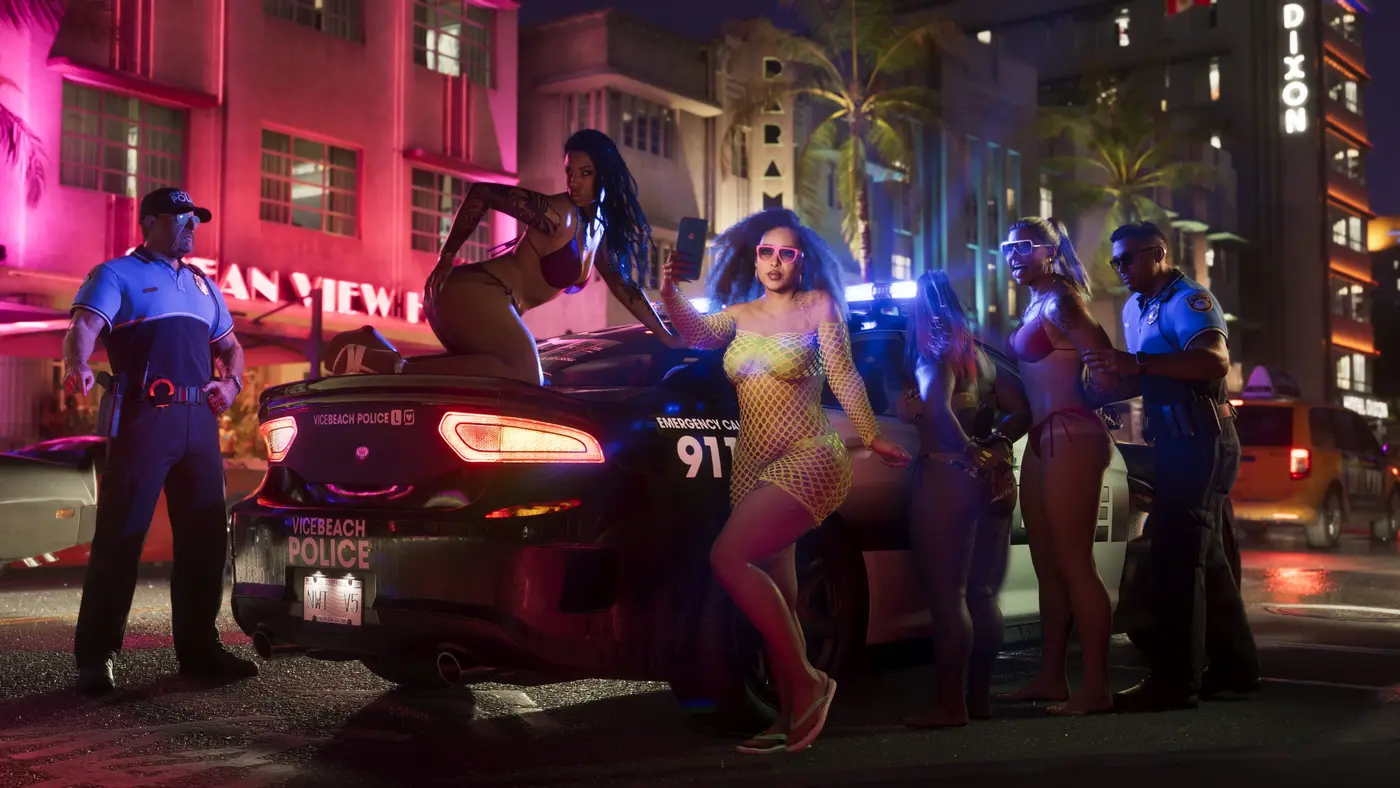 Scène nocturne sur une avenue de Vice City dans GTA VI : façades Art déco baignées de néons roses, une voiture VICEBEACH POLICE et des fêtardes en maillot prenant des selfies pendant une interpellation